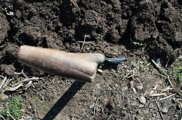 shovel inserted in dirt during a flood wall building process.