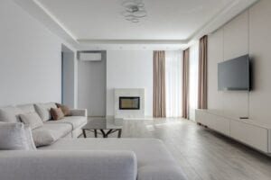 A Nicely Decorated Living Room With White Exterior Walls And A Grey Couch. How To Move Out Of Your Parents House?
