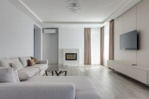 a nicely decorated living room with white exterior walls and a grey couch. How to move out of your parents house?