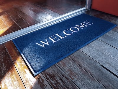 Blue Doormat With Welcome Text In Front Of Home