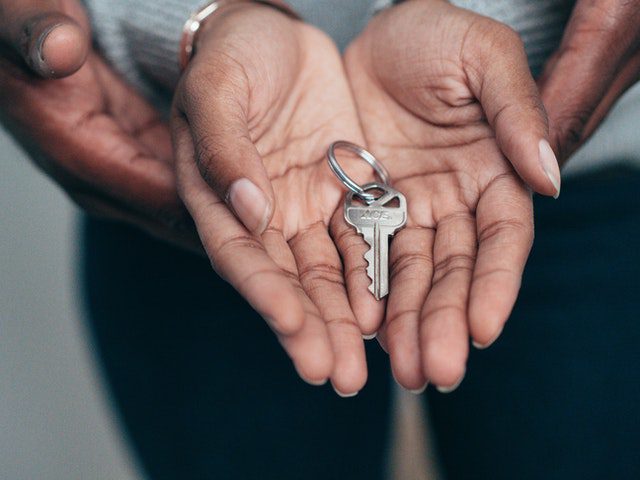 close-up of couple holding a key to a rented house. Questions to ask when renting a house